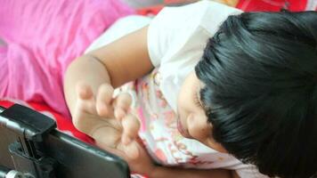 kind meisje gebruik makend van digitaal tablet zittend Aan een tafel video