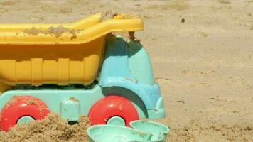 veelkleurig plastic speelgoed op een groot zandstrand aan zee video