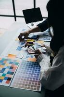 Close up ux developer and ui designer brainstorming about mobile app interface wireframe design on table with customer breif and color code at modern office.Creative digital development agency photo