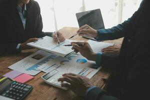 Financial analysts analyze business financial reports on a digital tablet planning investment project during a discussion at a meeting of corporate showing the results of their successful teamwork. photo
