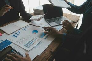Financial analysts analyze business financial reports on a digital tablet planning investment project during a discussion at a meeting of corporate showing the results of their successful teamwork. photo