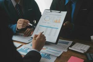 Financial analysts analyze business financial reports on a digital tablet planning investment project during a discussion at a meeting of corporate showing the results of their successful teamwork. photo