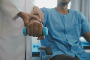 fisioterapeuta hombre dando ejercicio con pesa tratamiento acerca de brazo y hombro de atleta masculino paciente físico terapia concepto foto