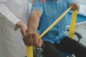 fisioterapeuta hombre dando ejercicio con pesa tratamiento acerca de brazo y hombro de atleta masculino paciente físico terapia concepto foto