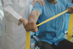 Physical therapist guiding patient with resistance band photo