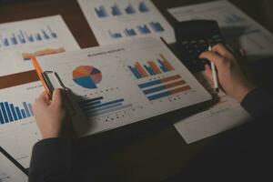 Close up businessman hand using calculator and working with laptop calculate about finance accounting at coffeeshop outdor.finance accounting concept photo