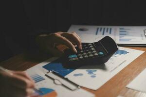 Close up businessman hand using calculator and working with laptop calculate about finance accounting at coffeeshop outdor.finance accounting concept photo