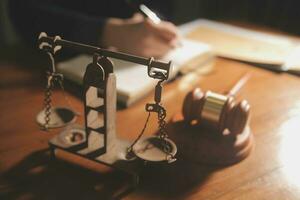 law books and scales of justice on desk in library of law firm. jurisprudence legal education concept. photo