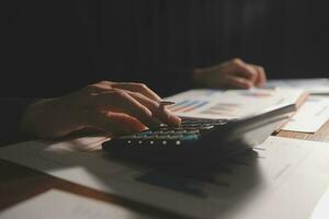 Close up businessman hand using calculator and working with laptop calculate about finance accounting at coffeeshop outdor.finance accounting concept photo