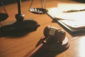 law books and scales of justice on desk in library of law firm. jurisprudence legal education concept. photo