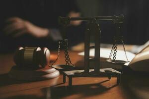 law books and scales of justice on desk in library of law firm. jurisprudence legal education concept. photo