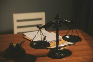 law books and scales of justice on desk in library of law firm. jurisprudence legal education concept. photo