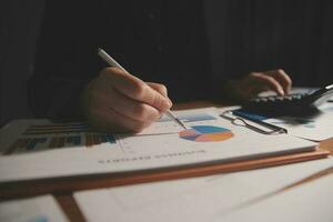 Close up businessman hand using calculator and working with laptop calculate about finance accounting at coffeeshop outdor.finance accounting concept photo