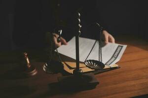 law books and scales of justice on desk in library of law firm. jurisprudence legal education concept. photo