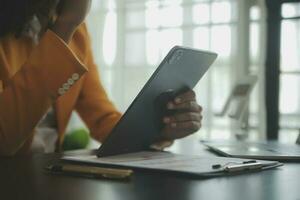 Close up Business woman using calculator and laptop for do math finance on wooden desk, tax, accounting, statistics and analytical research concept photo