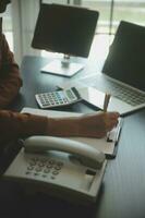 Close up Business woman using calculator and laptop for do math finance on wooden desk, tax, accounting, statistics and analytical research concept photo
