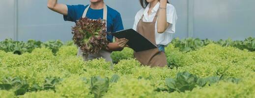 View of an attractive farmer in a greenhouse using tablet photo