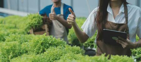 View of an attractive farmer in a greenhouse using tablet photo