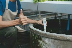 View of an attractive farmer in a greenhouse using tablet photo