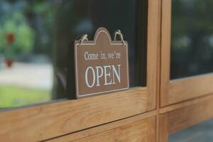 Welcome. Open. barista, waitress woman turning open sign board on glass door in modern cafe coffee shop ready to service, cafe restaurant, retail store, small business owner, food and drink concept photo