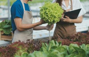 View of an attractive farmer in a greenhouse using tablet photo