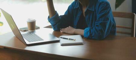 el retrato de una joven mujer asiática independiente está trabajando en su trabajo en una tableta de computadora en una oficina moderna. hacer un informe de análisis contable datos de inversión inmobiliaria, concepto de sistemas financieros y fiscales. foto