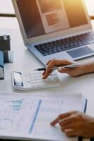 businessman working on desk office with using a calculator to calculate the numbers, finance accounting concept photo
