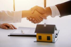 Accountant, businessman, real estate agent, Asian business woman handing keys to customers along with house after customers to sign photo