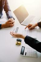 A car rental company employee is handing out the car keys to the renter after discussing the rental details and conditions together with the renter signing a car rental agreement. Concept car rental. photo