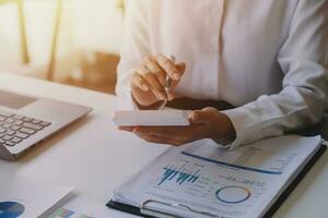 businessman working on desk office with using a calculator to calculate the numbers, finance accounting concept photo