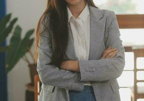 Asian Business woman using calculator and laptop for doing math finance on an office desk, tax, report, accounting, statistics, and analytical research concept photo