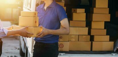 Delivery man with cardboard box checking document list In van and parcels on seat outside the warehouse. photo