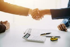 Hand holding car keys and car rental concept A close-up view of the agent, giving the customer the car keys after signing the lease, rental form and car name. photo