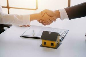 Accountant, businessman, real estate agent, Asian business woman handing keys to customers along with house after customers to sign photo