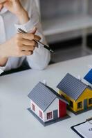 Accountant, businessman, real estate agent, Asian business woman handing keys to customers along with house after customers to sign photo