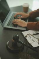 Business and lawyers discussing contract papers with brass scale on desk in office. Law, legal services, advice, justice and law concept picture with film grain effect photo