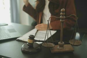 Business and lawyers discussing contract papers with brass scale on desk in office. Law, legal services, advice, justice and law concept picture with film grain effect photo