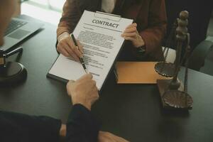 Business and lawyers discussing contract papers with brass scale on desk in office. Law, legal services, advice, justice and law concept picture with film grain effect photo