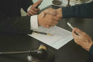 Business and lawyers discussing contract papers with brass scale on desk in office. Law, legal services, advice, justice and law concept picture with film grain effect photo