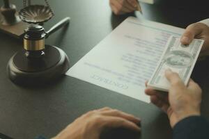 Business and lawyers discussing contract papers with brass scale on desk in office. Law, legal services, advice, justice and law concept picture with film grain effect photo