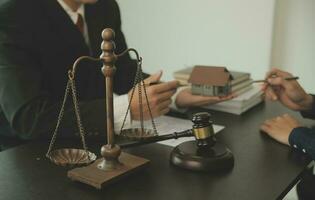 Business and lawyers discussing contract papers with brass scale on desk in office. Law, legal services, advice, justice and law concept picture with film grain effect photo