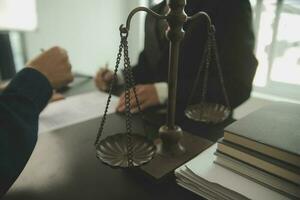 Business and lawyers discussing contract papers with brass scale on desk in office. Law, legal services, advice, justice and law concept picture with film grain effect photo