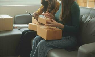 mujer de negocios puesta en marcha empresaria de pequeña empresa sme éxito. mujer independiente que trabaja en casa con entrega de paquetes en línea. concepto de entrega de pymes y embalajes foto