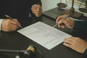 Business and lawyers discussing contract papers with brass scale on desk in office. Law, legal services, advice, justice and law concept picture with film grain effect photo