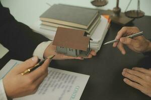 Business and lawyers discussing contract papers with brass scale on desk in office. Law, legal services, advice, justice and law concept picture with film grain effect photo