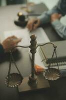 Business and lawyers discussing contract papers with brass scale on desk in office. Law, legal services, advice, justice and law concept picture with film grain effect photo