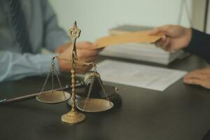 Business and lawyers discussing contract papers with brass scale on desk in office. Law, legal services, advice, justice and law concept picture with film grain effect photo