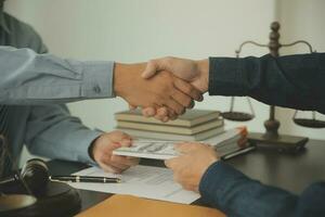 Business and lawyers discussing contract papers with brass scale on desk in office. Law, legal services, advice, justice and law concept picture with film grain effect photo