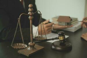 Business and lawyers discussing contract papers with brass scale on desk in office. Law, legal services, advice, justice and law concept picture with film grain effect photo