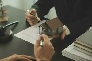 Business and lawyers discussing contract papers with brass scale on desk in office. Law, legal services, advice, justice and law concept picture with film grain effect photo